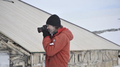 Ian Godfrey documenting the exterior fabric of Mawson's Main Hut at Cape Denison in 2012